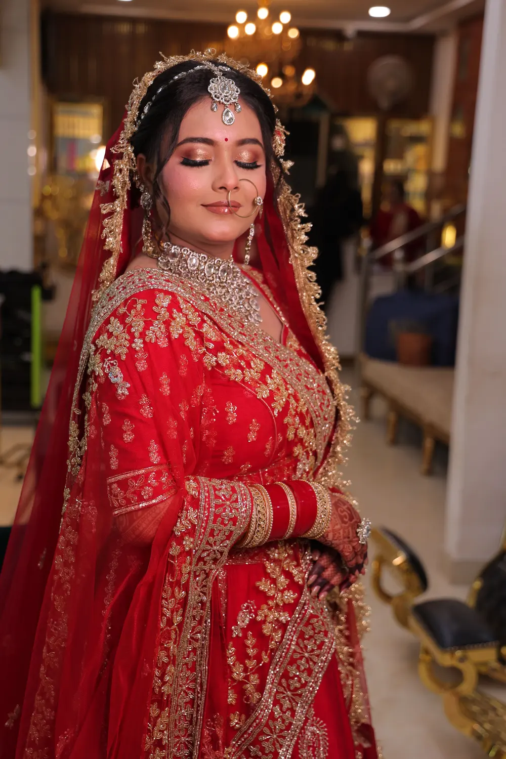 Bride in a red lehenga with bridal makeup by Ruby Makeover